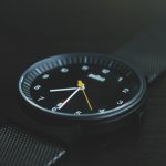 round black Braun analog watch with black band at 7:30